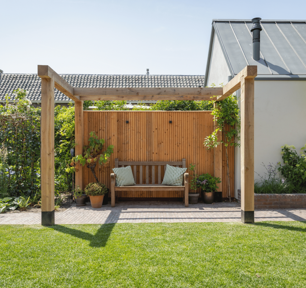 Houten pergola met rustgevend zitplekje in achtertuin