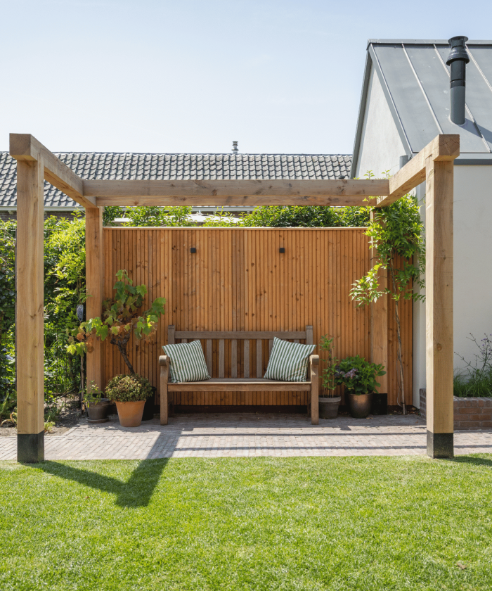 Houten pergola met rustgevend zitplekje in achtertuin